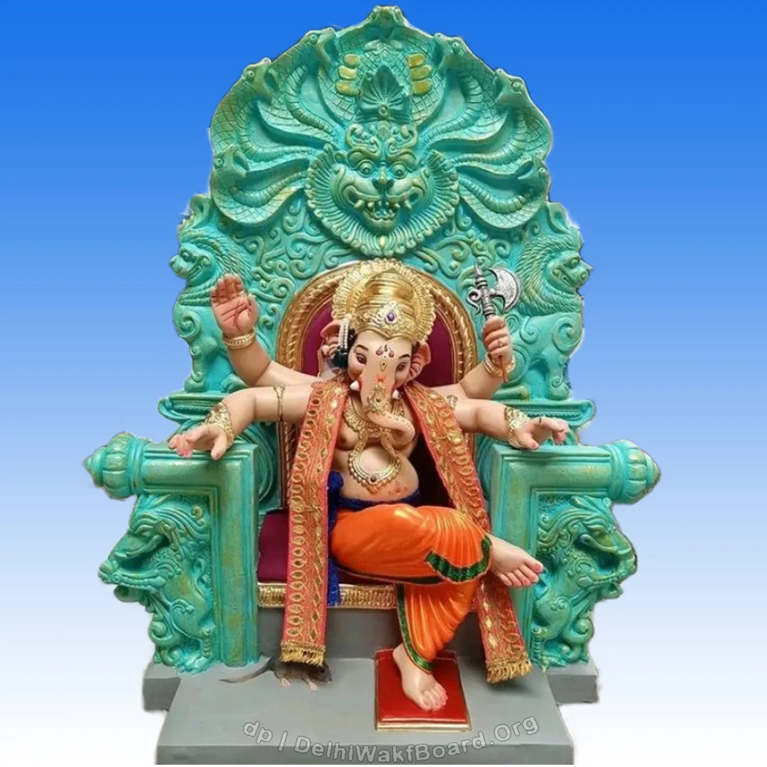 God Ganesh sitting on a giant sofa with his leg over another happy and blessing us. He is wearing orange, red, and gold mixed cloth.